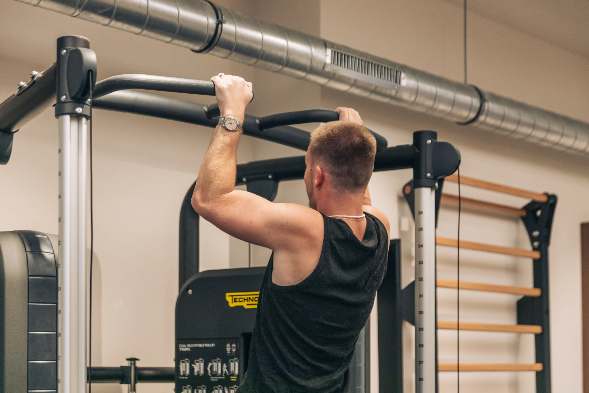 Male patient doing pull-ups on the bar in the rehabilitation gym