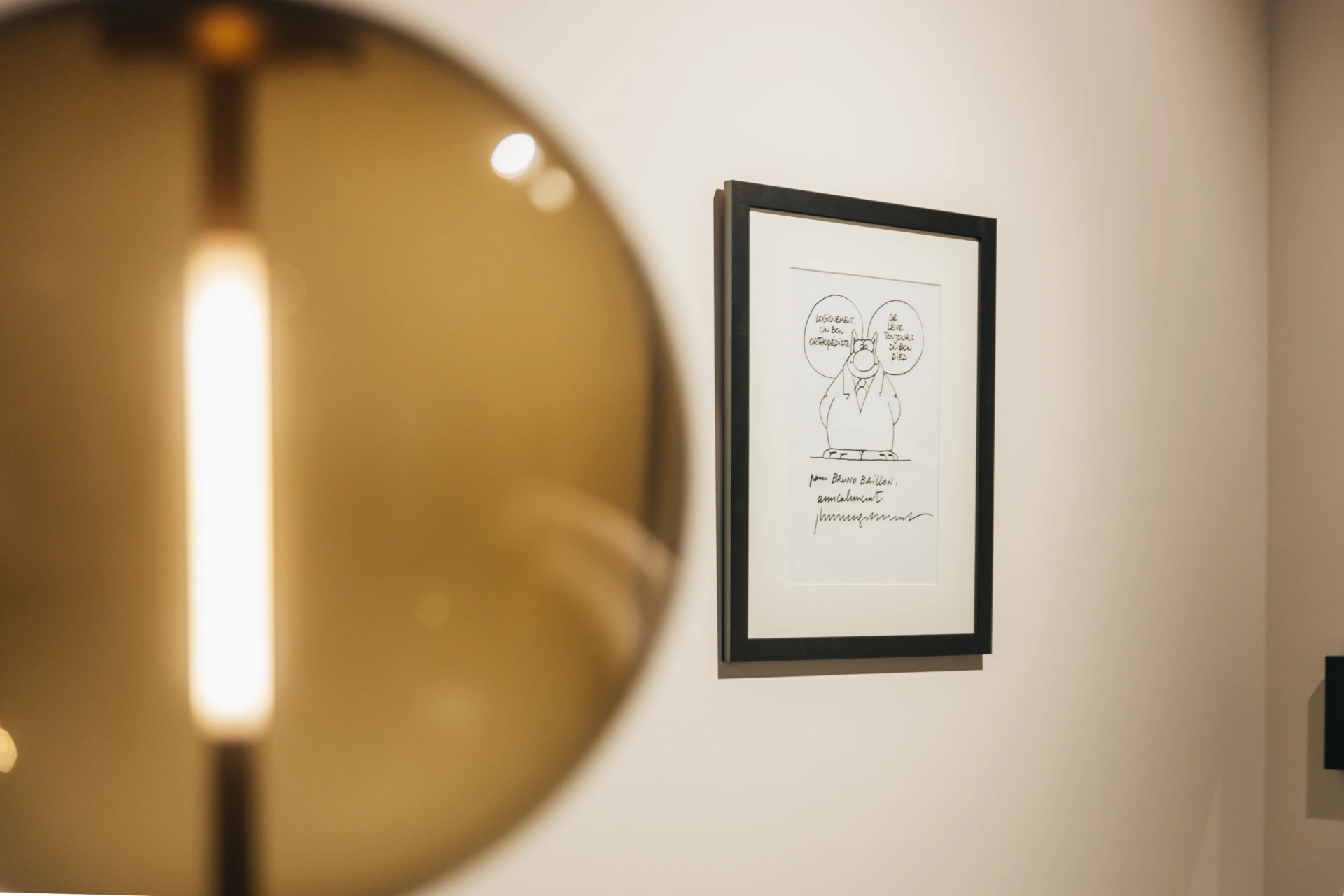 Luminaire et dessin encadré dans un couloir du centre