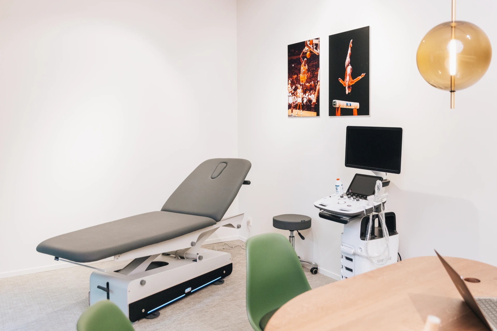 Examination couch, ultrasound machine and screen in a bright consulting room